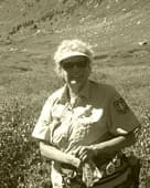 A volunteer ranger holding a map in an alpine valley